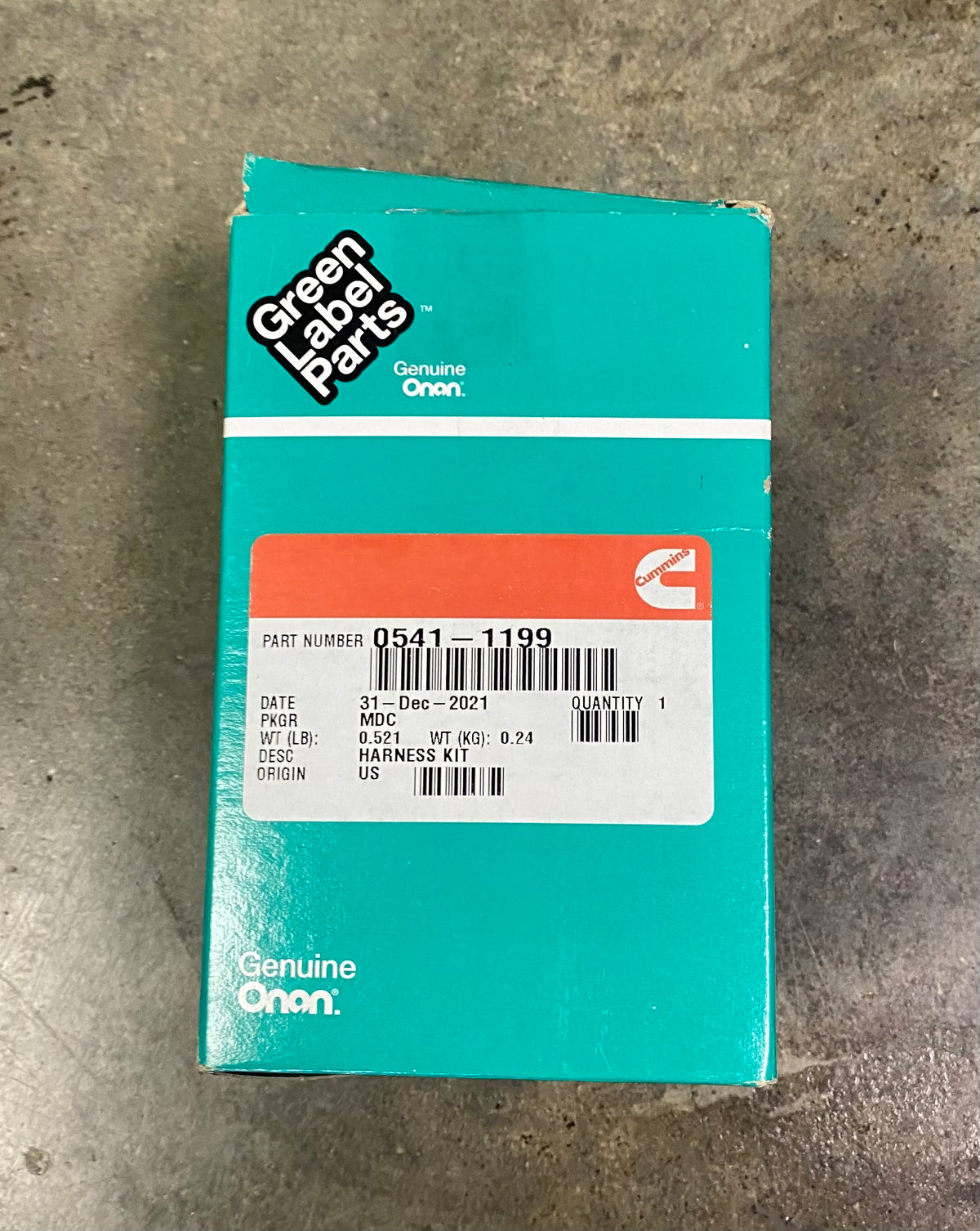 A teal Genuine On Green Label Parts box for a harness kit, showing part number 0541-1199, photographed on a gray concrete floor.